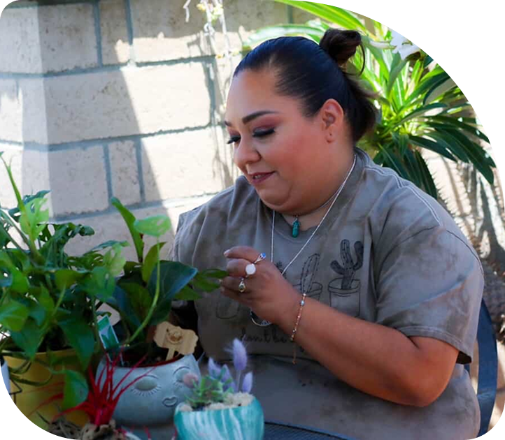 Woman caring for plants during a mindfulness and creative healing activity